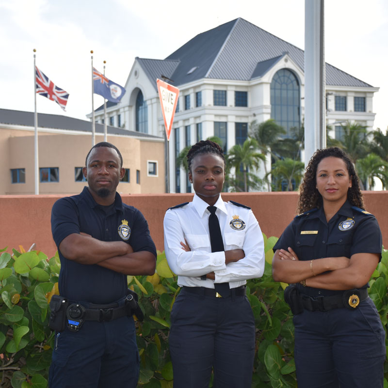 Three officers standing in front of buildings